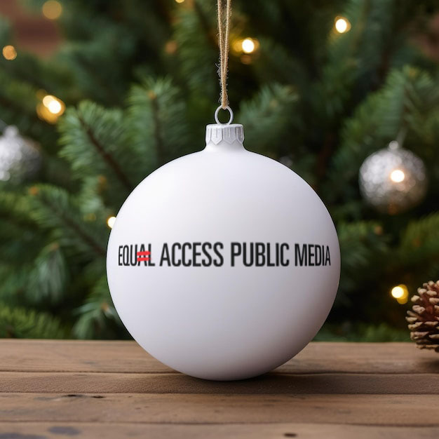 A white Christmas ornament with the Equal Access Public Media logo on it in front of a tree